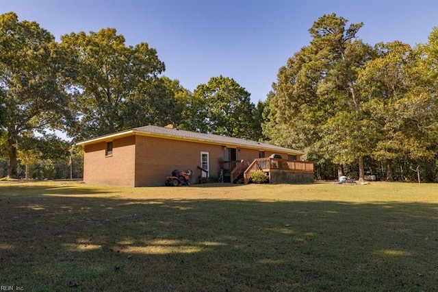 back of house featuring a wooden deck and a yard