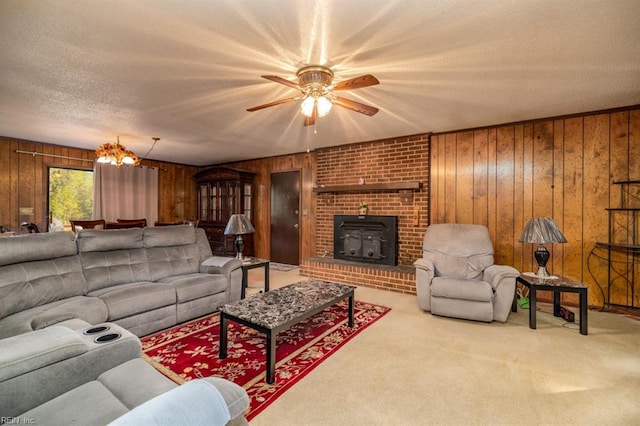 carpeted living room with wood walls, ceiling fan, a textured ceiling, and a wood stove