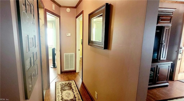 hallway with crown molding and hardwood / wood-style floors