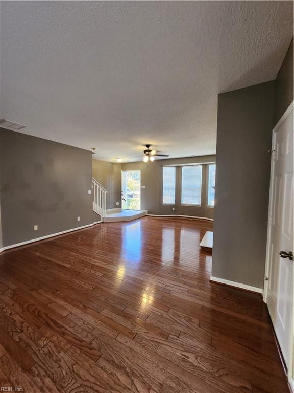 unfurnished living room featuring ceiling fan, wood-type flooring, and a textured ceiling