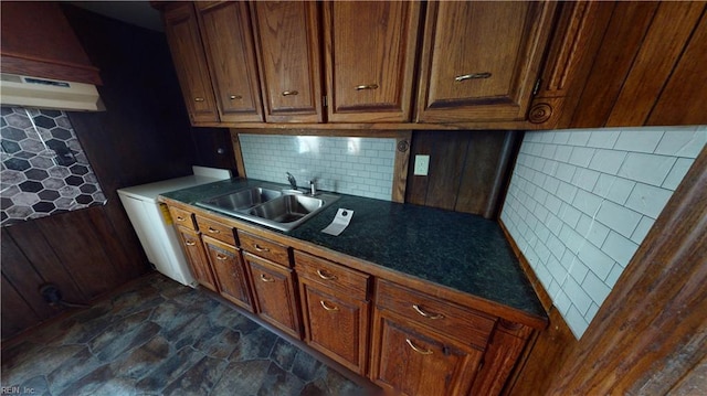 kitchen featuring washer / dryer, tasteful backsplash, and sink