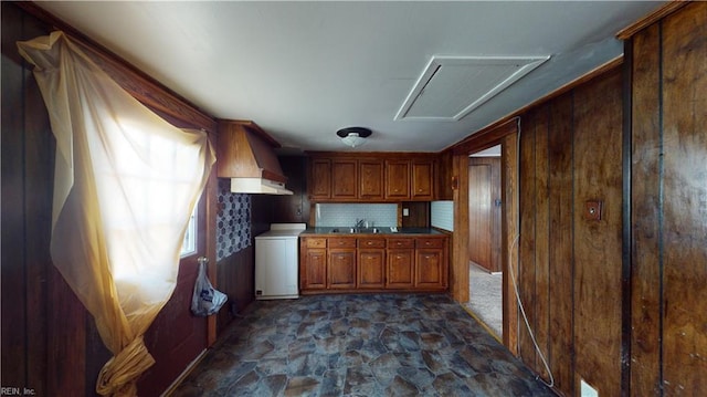 kitchen featuring decorative backsplash, sink, and wooden walls