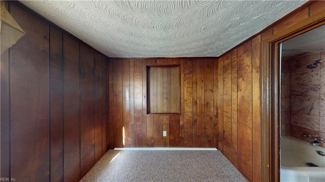 interior space with wood walls and a textured ceiling