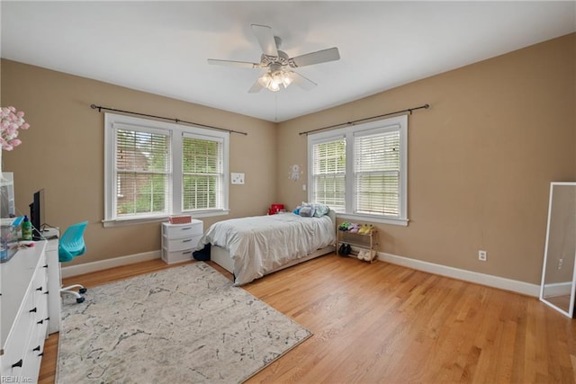 bedroom with hardwood / wood-style flooring, multiple windows, and ceiling fan