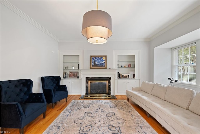 living room with built in features, ornamental molding, and light hardwood / wood-style flooring