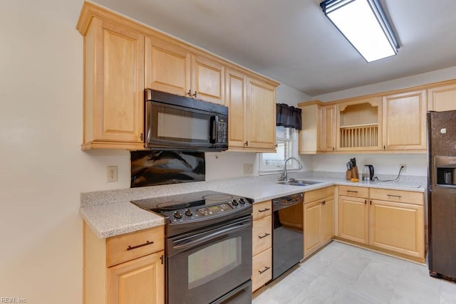 kitchen featuring light stone countertops, light brown cabinetry, black appliances, and sink