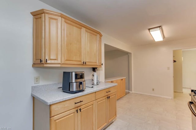 kitchen featuring light brown cabinets and stainless steel range oven