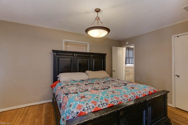 bedroom featuring crown molding and light wood-type flooring