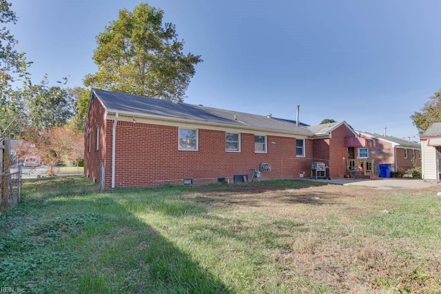 rear view of property with a patio area and a lawn