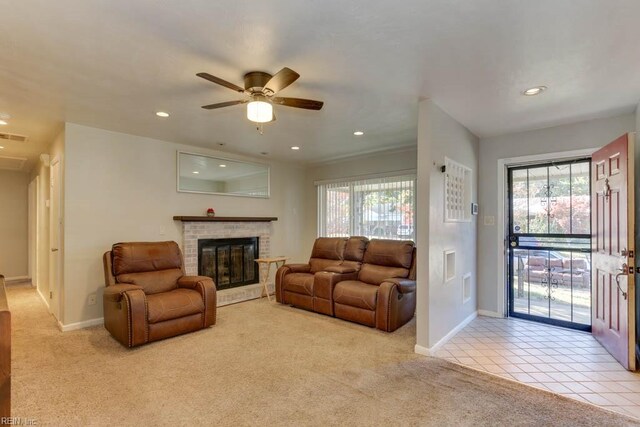 living room with light carpet, a brick fireplace, ceiling fan, and a wealth of natural light