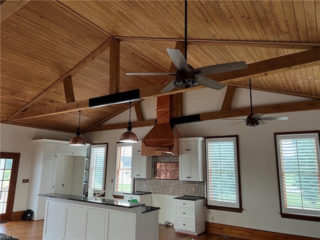 kitchen with vaulted ceiling with beams, wood ceiling, white cabinets, hardwood / wood-style floors, and pendant lighting