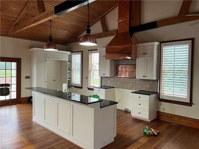 kitchen with white cabinets, hanging light fixtures, a center island with sink, and dark hardwood / wood-style floors