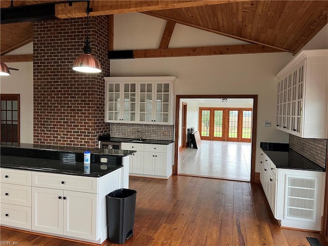 kitchen featuring hardwood / wood-style flooring, tasteful backsplash, wood ceiling, white cabinets, and pendant lighting