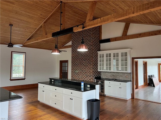 kitchen featuring hanging light fixtures, hardwood / wood-style flooring, and white cabinets