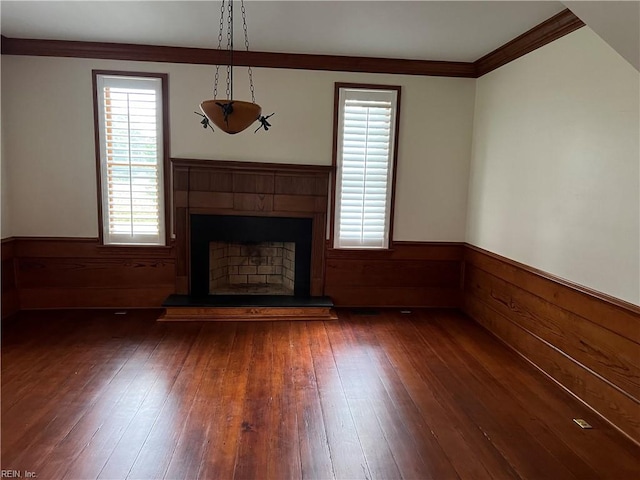 unfurnished living room featuring dark wood-type flooring, wood walls, and crown molding