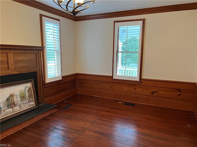 unfurnished living room with ornamental molding, a notable chandelier, and dark hardwood / wood-style floors