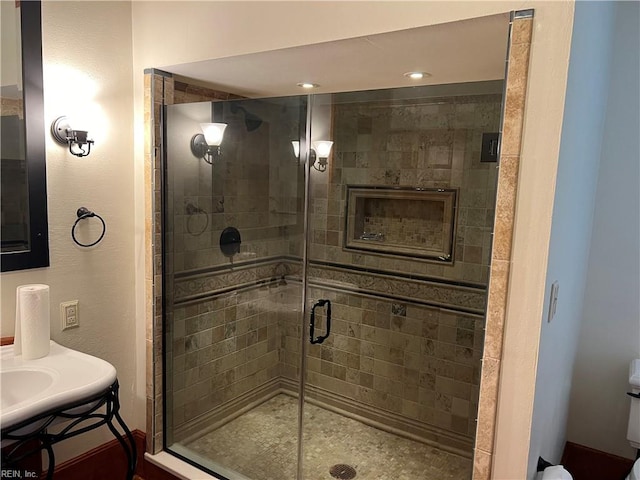 bathroom featuring a shower with shower door, vanity, and toilet