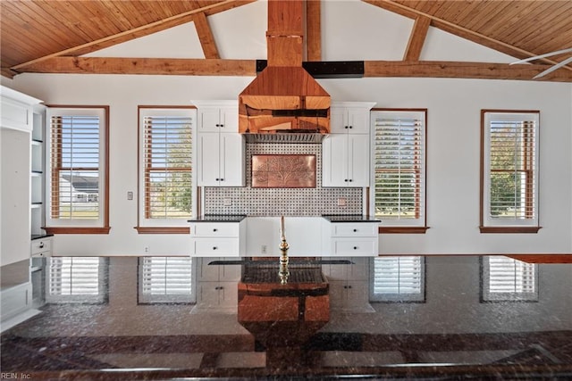 kitchen with white cabinetry, vaulted ceiling with beams, and wooden ceiling