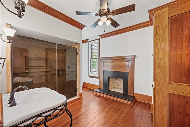 bathroom featuring walk in shower, hardwood / wood-style flooring, ceiling fan, and crown molding