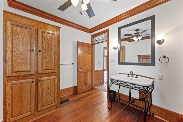 bathroom with ceiling fan, hardwood / wood-style floors, and ornamental molding