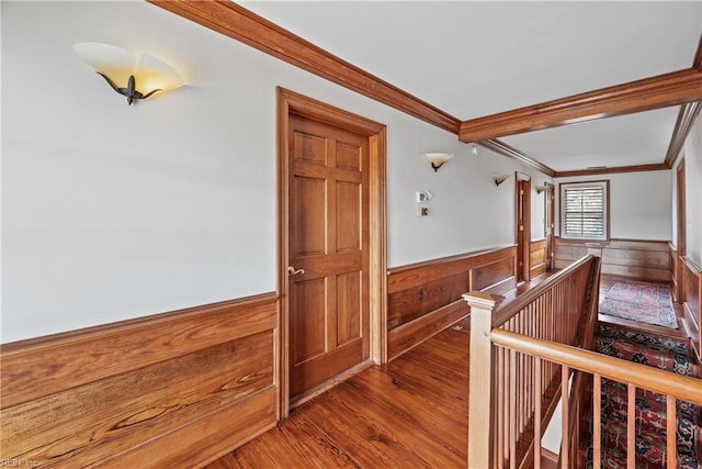 hall featuring wooden walls, hardwood / wood-style floors, and ornamental molding