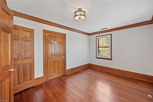 interior space featuring wood-type flooring and crown molding