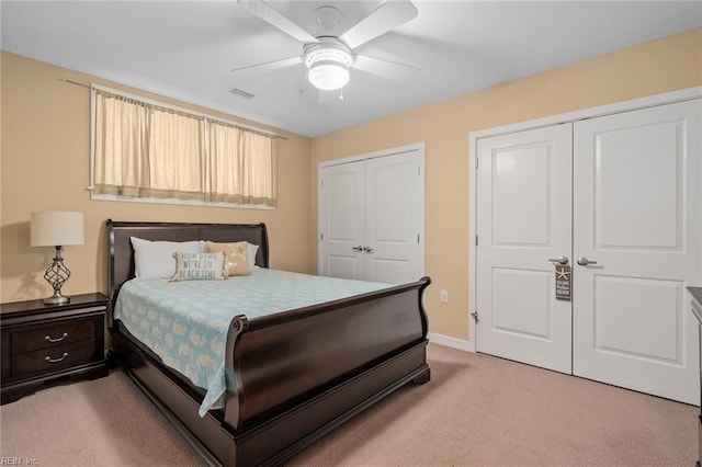 carpeted bedroom with multiple closets and ceiling fan