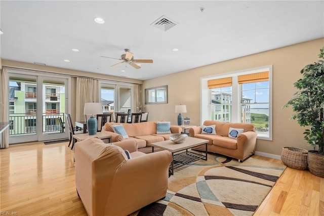 living room featuring light hardwood / wood-style floors, a wealth of natural light, and ceiling fan