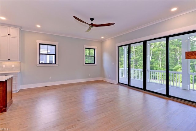 unfurnished living room featuring crown molding, light hardwood / wood-style floors, and ceiling fan