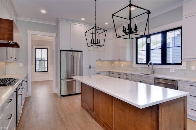 kitchen featuring appliances with stainless steel finishes, a wealth of natural light, a kitchen island, and white cabinets