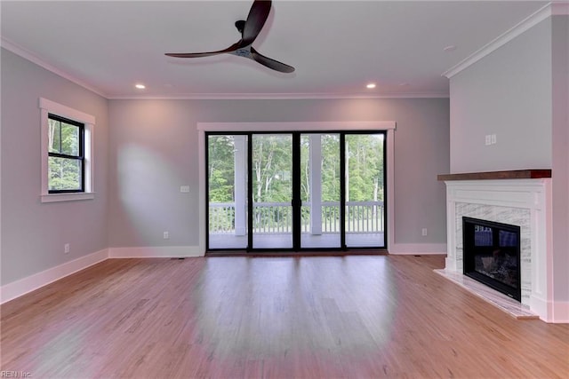 unfurnished living room featuring a ceiling fan, ornamental molding, and wood finished floors