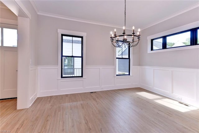 unfurnished dining area with crown molding, light hardwood / wood-style flooring, and a chandelier