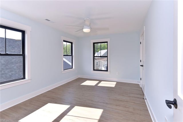 unfurnished room featuring visible vents, a ceiling fan, baseboards, and wood finished floors
