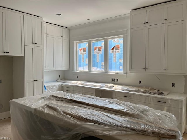 kitchen with light stone counters and white cabinetry