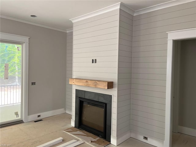 unfurnished living room with baseboards, a glass covered fireplace, ornamental molding, and visible vents