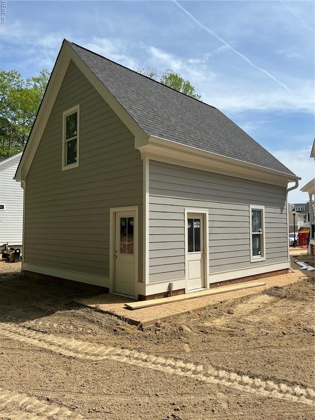 rear view of property featuring a shingled roof