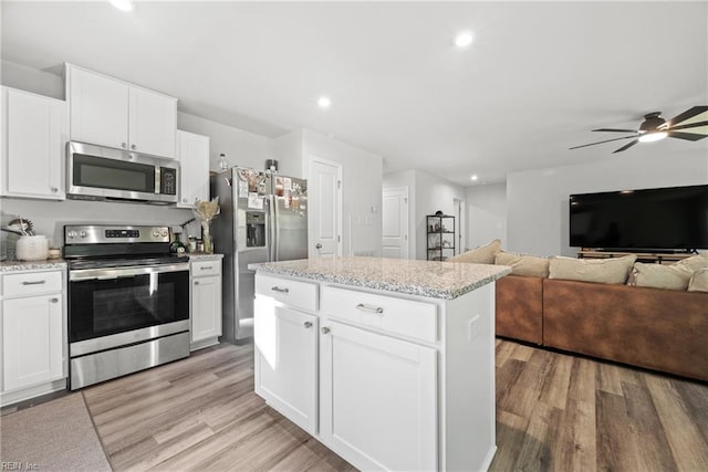 kitchen featuring appliances with stainless steel finishes, white cabinets, and a center island