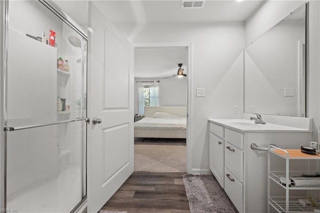 bathroom with vanity, ceiling fan, wood-type flooring, and an enclosed shower