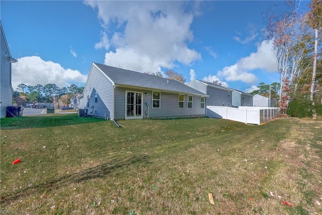 rear view of property featuring central AC and a yard