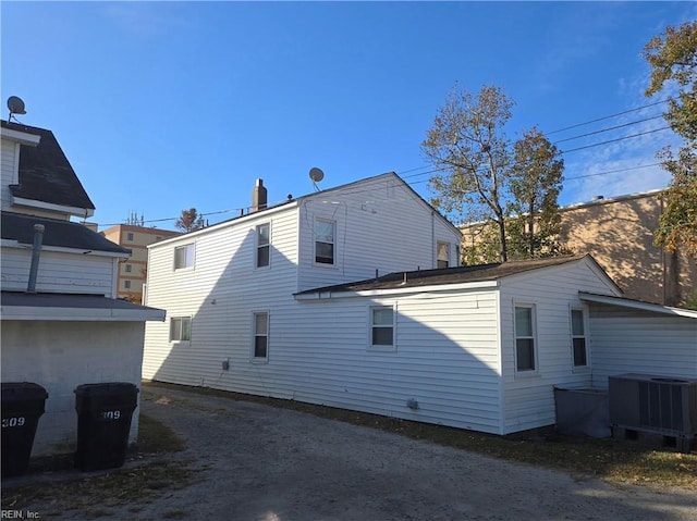 rear view of house featuring central air condition unit