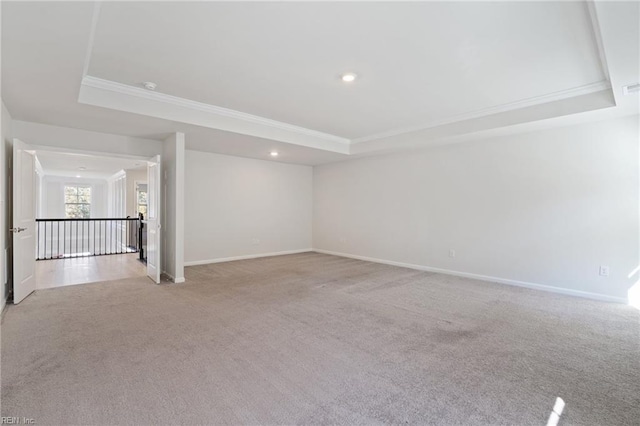 unfurnished room featuring light carpet, crown molding, and a tray ceiling