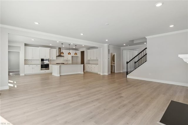 unfurnished living room featuring light hardwood / wood-style flooring and ornamental molding