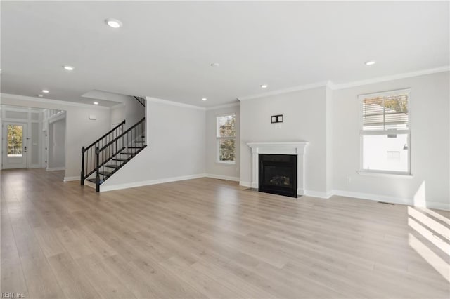 unfurnished living room featuring light hardwood / wood-style flooring and crown molding