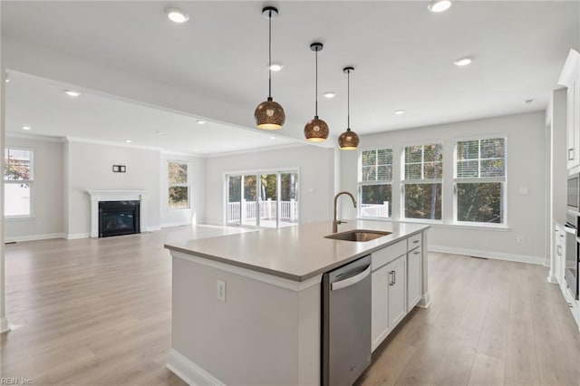 kitchen with white cabinetry, sink, plenty of natural light, and a center island with sink