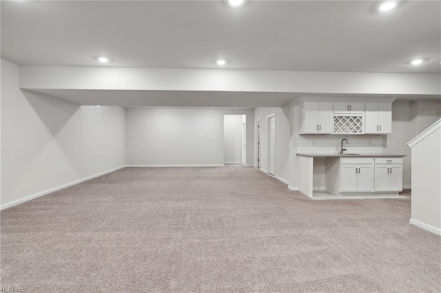 basement featuring indoor wet bar and light colored carpet