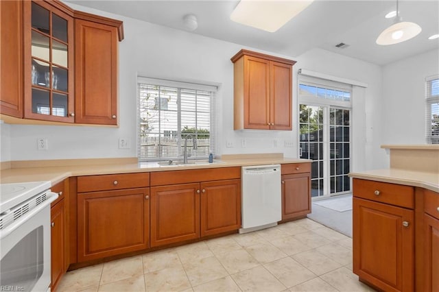 kitchen featuring a healthy amount of sunlight, sink, white appliances, and light tile patterned floors