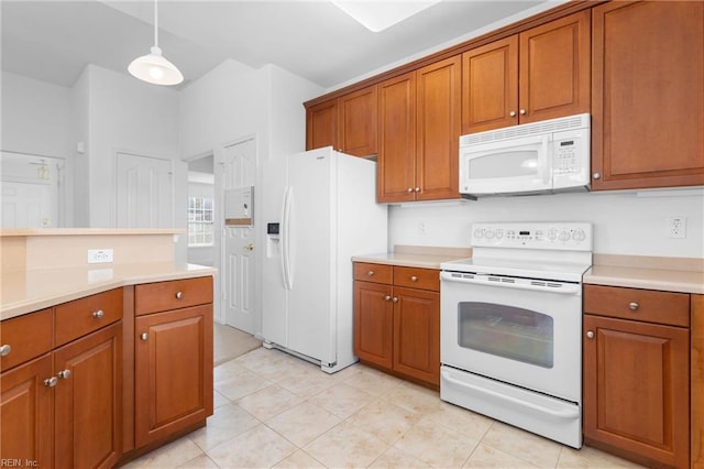 kitchen featuring white appliances, light tile patterned floors, and pendant lighting