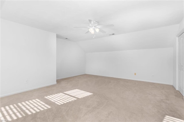 additional living space featuring light carpet, vaulted ceiling, and ceiling fan