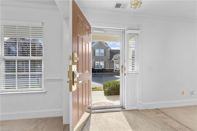 foyer featuring carpet and ornamental molding