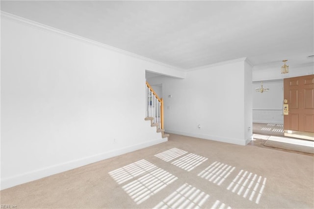 spare room featuring light carpet, crown molding, and an inviting chandelier